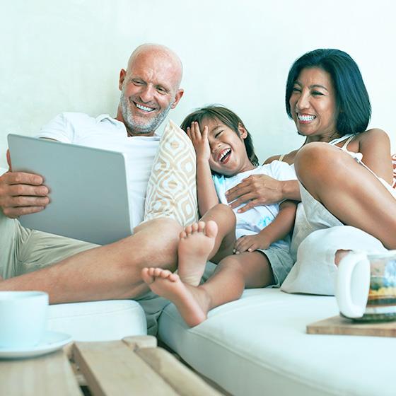 A family laughing around a tablet
